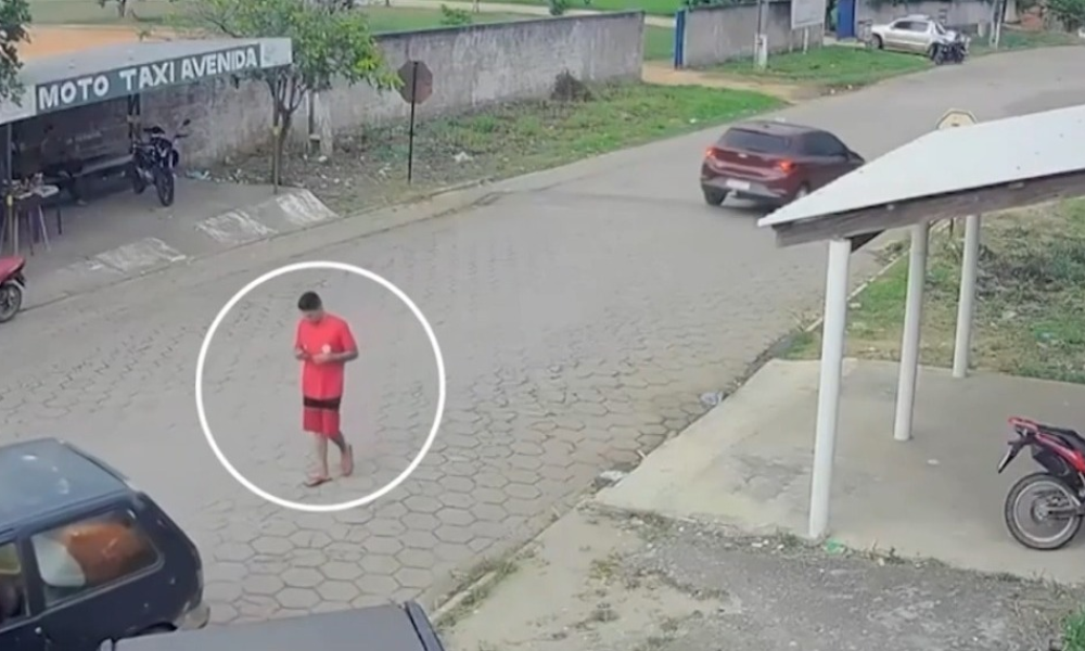 câmeras de segurança. As imagens mostram a vítima, usando camisa vermelha, camin