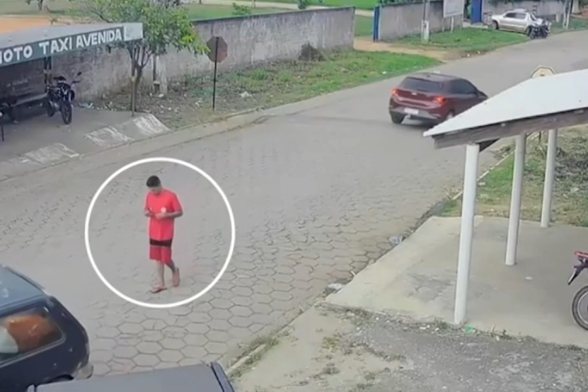 câmeras de segurança. As imagens mostram a vítima, usando camisa vermelha, camin