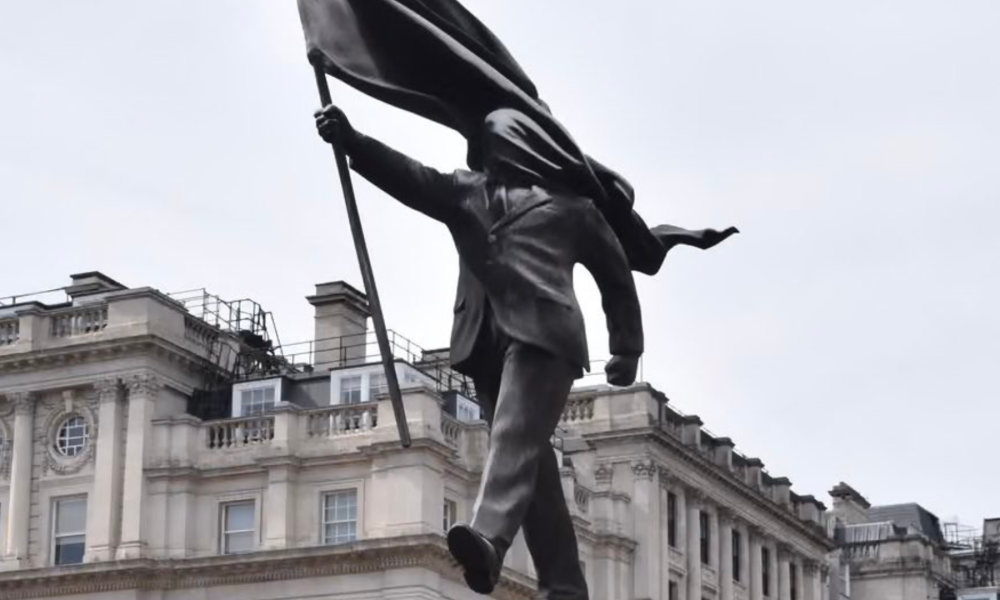 Na imagem, a obra de Banksy, um homem de terno descendo de um pedestal