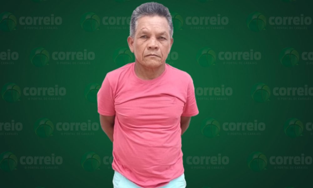 Homem com camiseta rosa e cabelo grisalho em fundo verde com logo de jornal.
