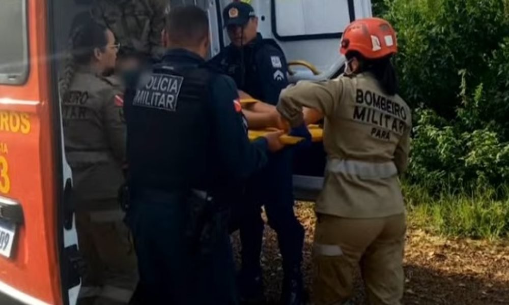 Equipe de resgate colocando pessoa em maca na ambulância dos Bombeiros.