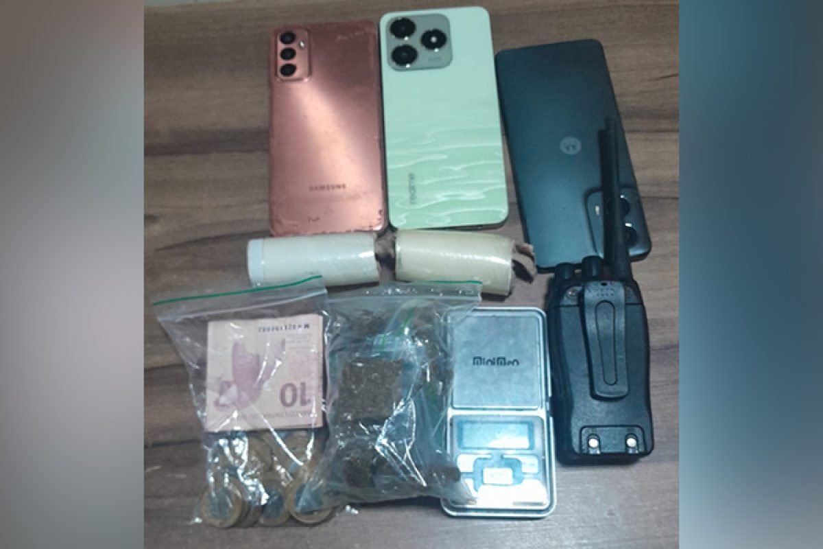 Objetos apreendidos: três celulares, dois pacotes cilíndricos, dinheiro, substância vegetal e balança digital, com um rádio comunicador.