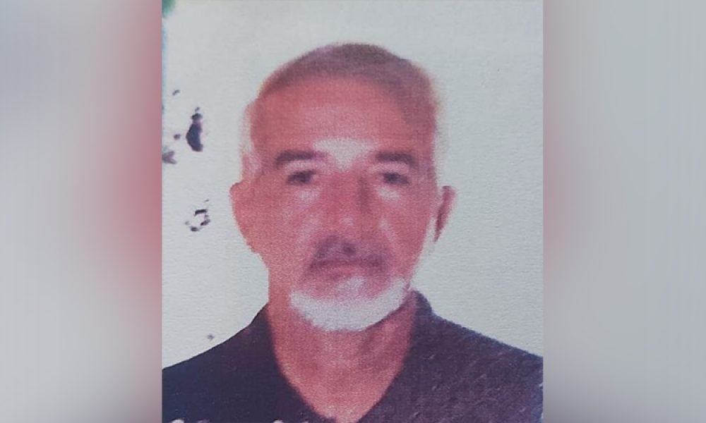 Homem de meia-idade com cabelo e barba grisalhos, vestindo camisa escura, em foto de rosto.
