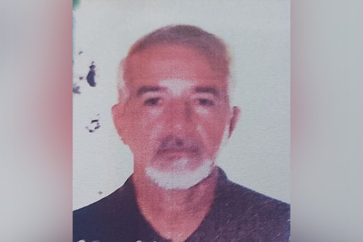 Homem de meia-idade com cabelo e barba grisalhos, vestindo camisa escura, em foto de rosto.